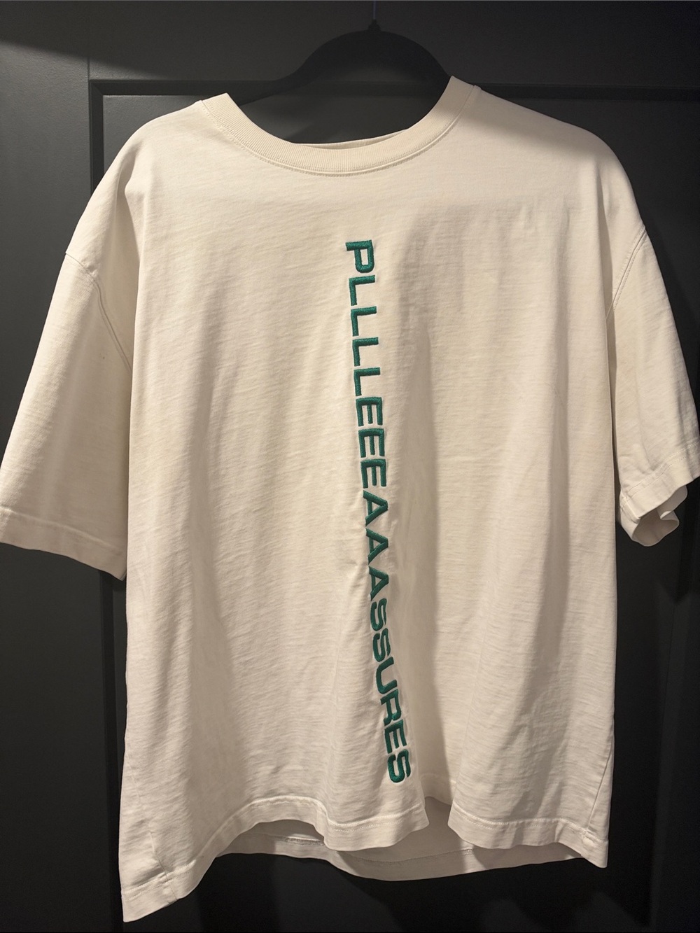White PLEASURES Short-Sleeve Graphic Tee with Vertical Green Lettering